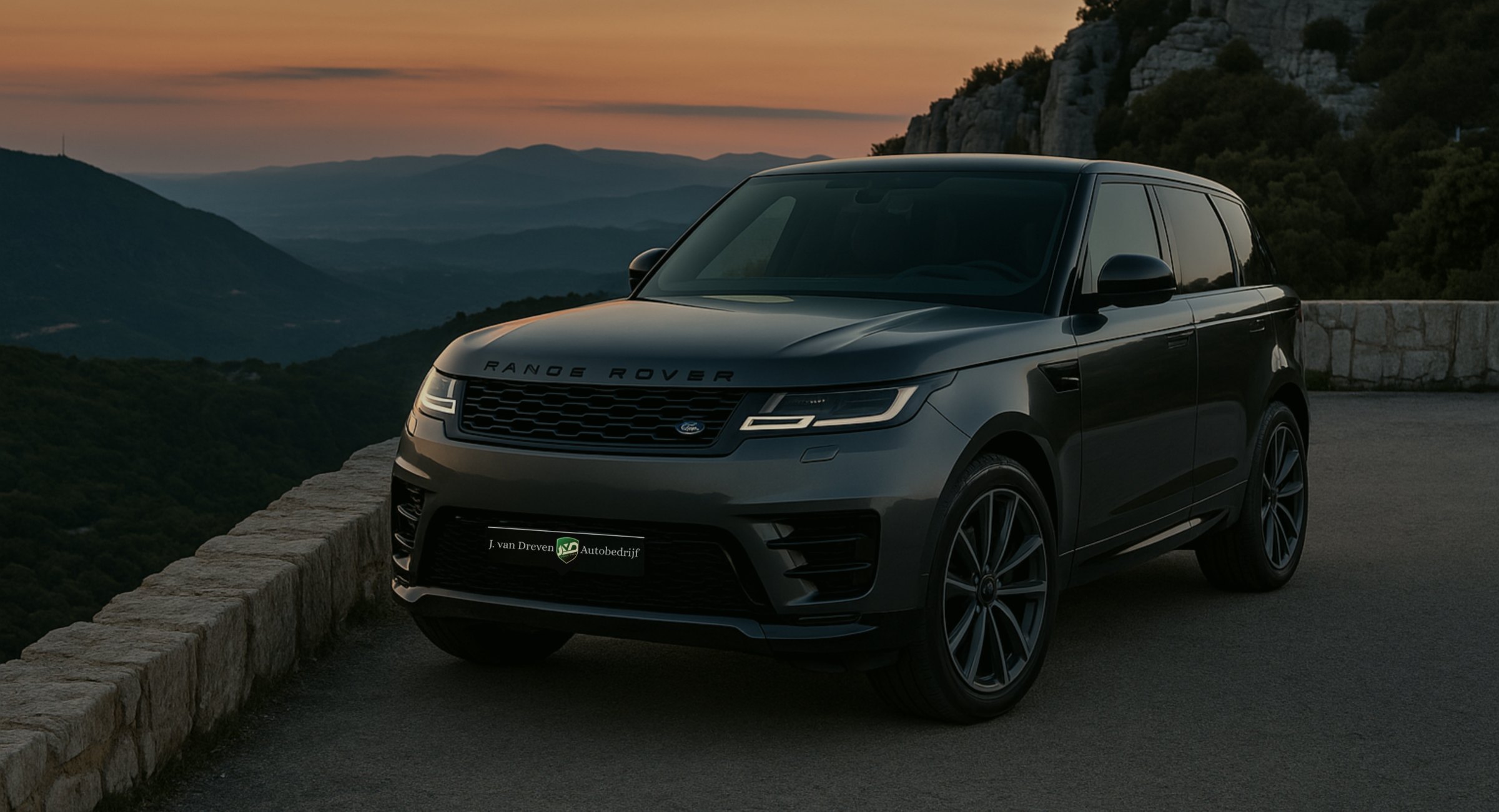 Een donkergrijze Range Rover Sport met het naambord van Autobedrijf J. van Dreven, bij zonsondergang in de bergen