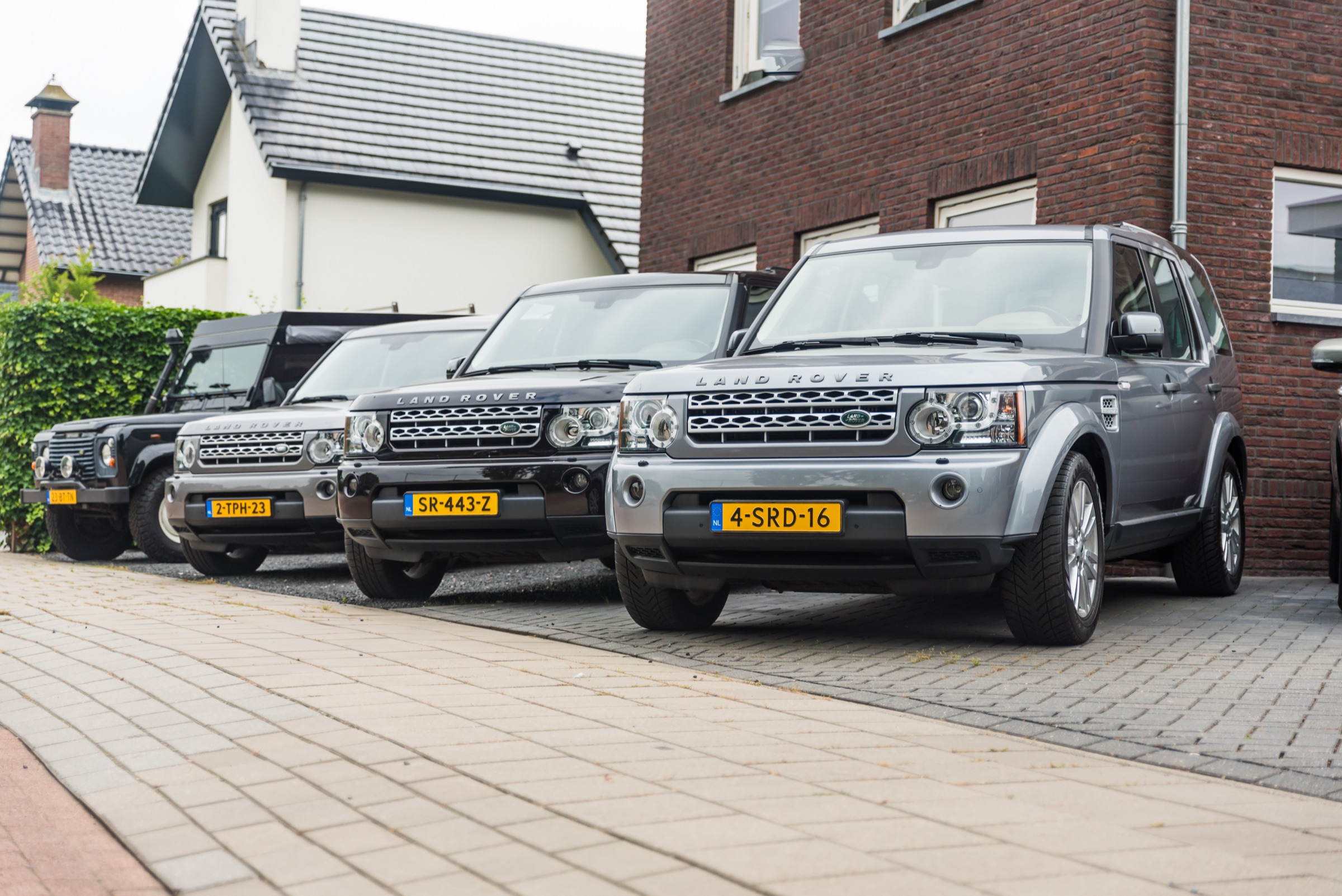 Een rij Land Rovers voor het pand van Autobedrijf J. van Dreven